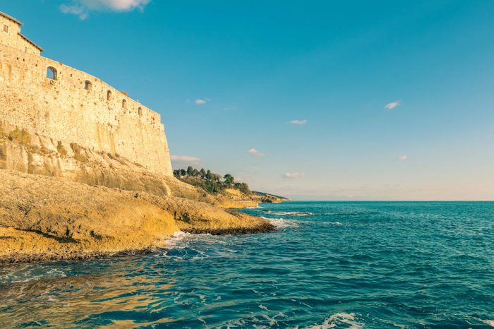 Explore the historic Ulcinj fortress overlooking the stunning Adriatic coastline under a clear summer sky.