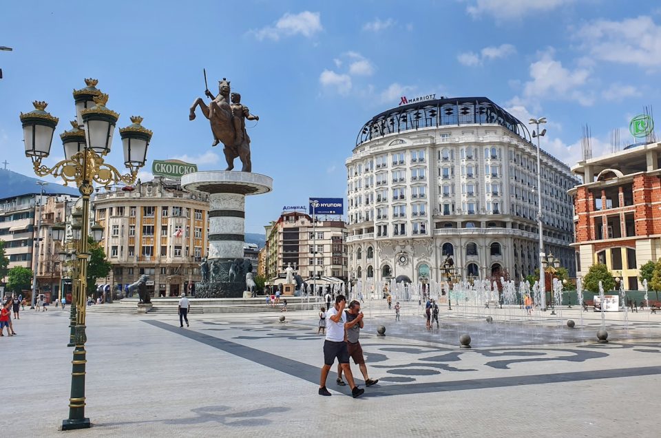 people walking on park near white concrete building during daytime